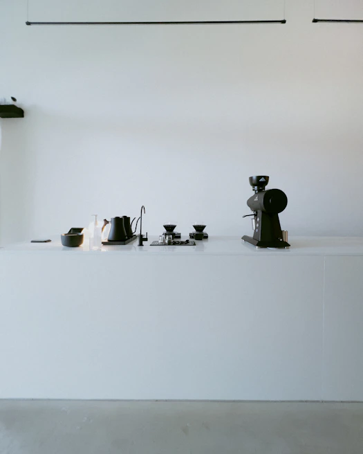 A minimalist kitchen setup featuring a smart coffee maker brewing a fresh cup