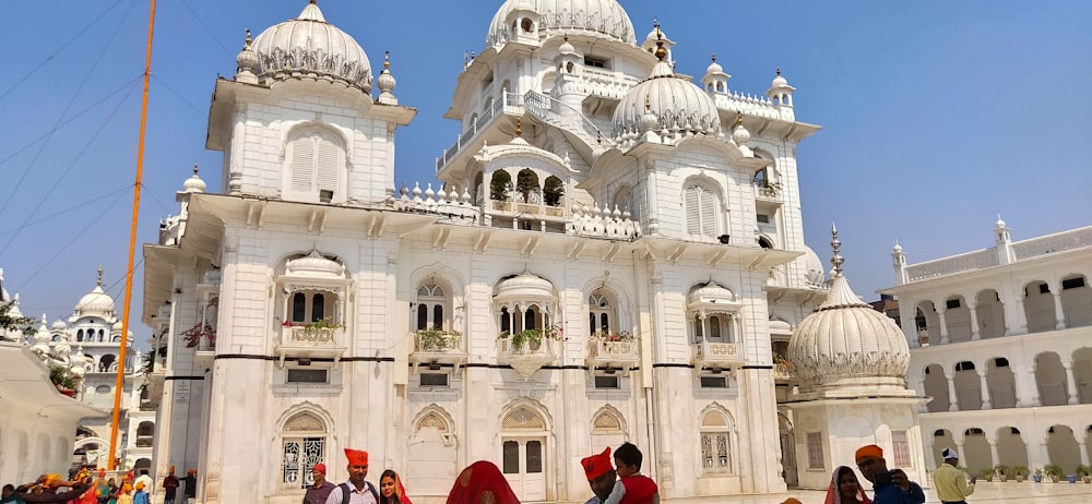 a group of people standing in front of a white building