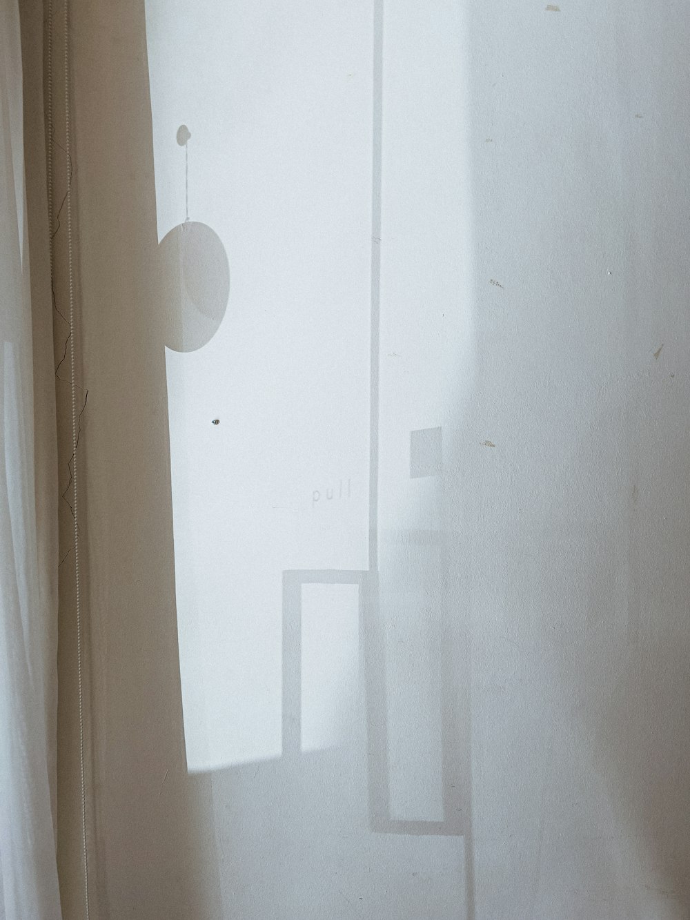 a cat sitting on a window sill next to a curtain