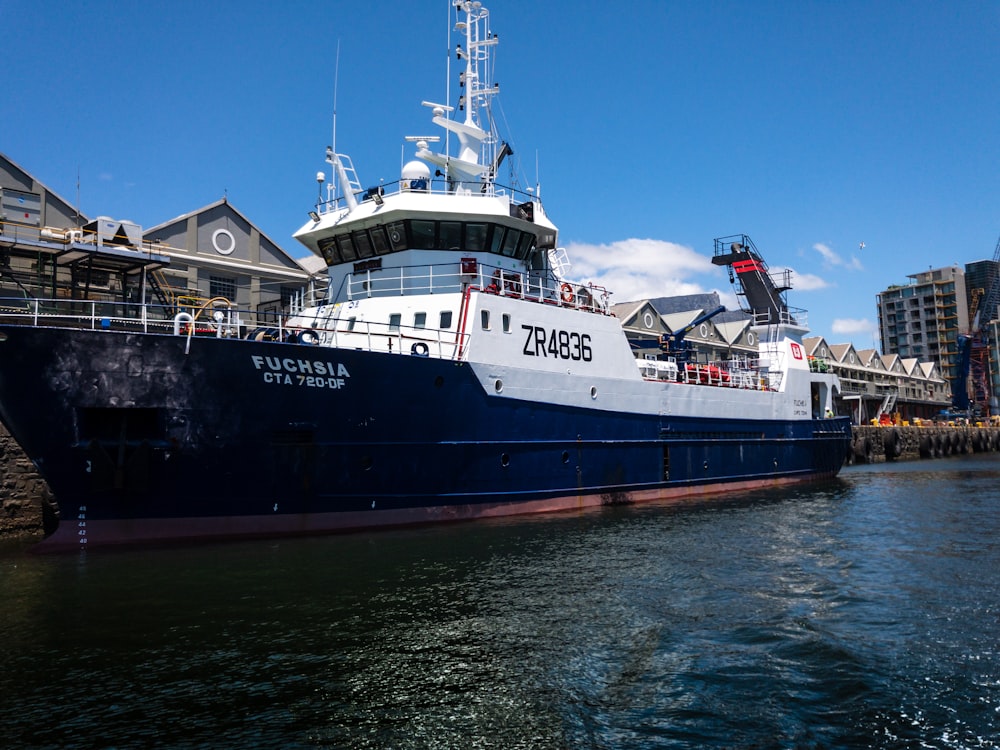 a blue and white boat docked in a harbor