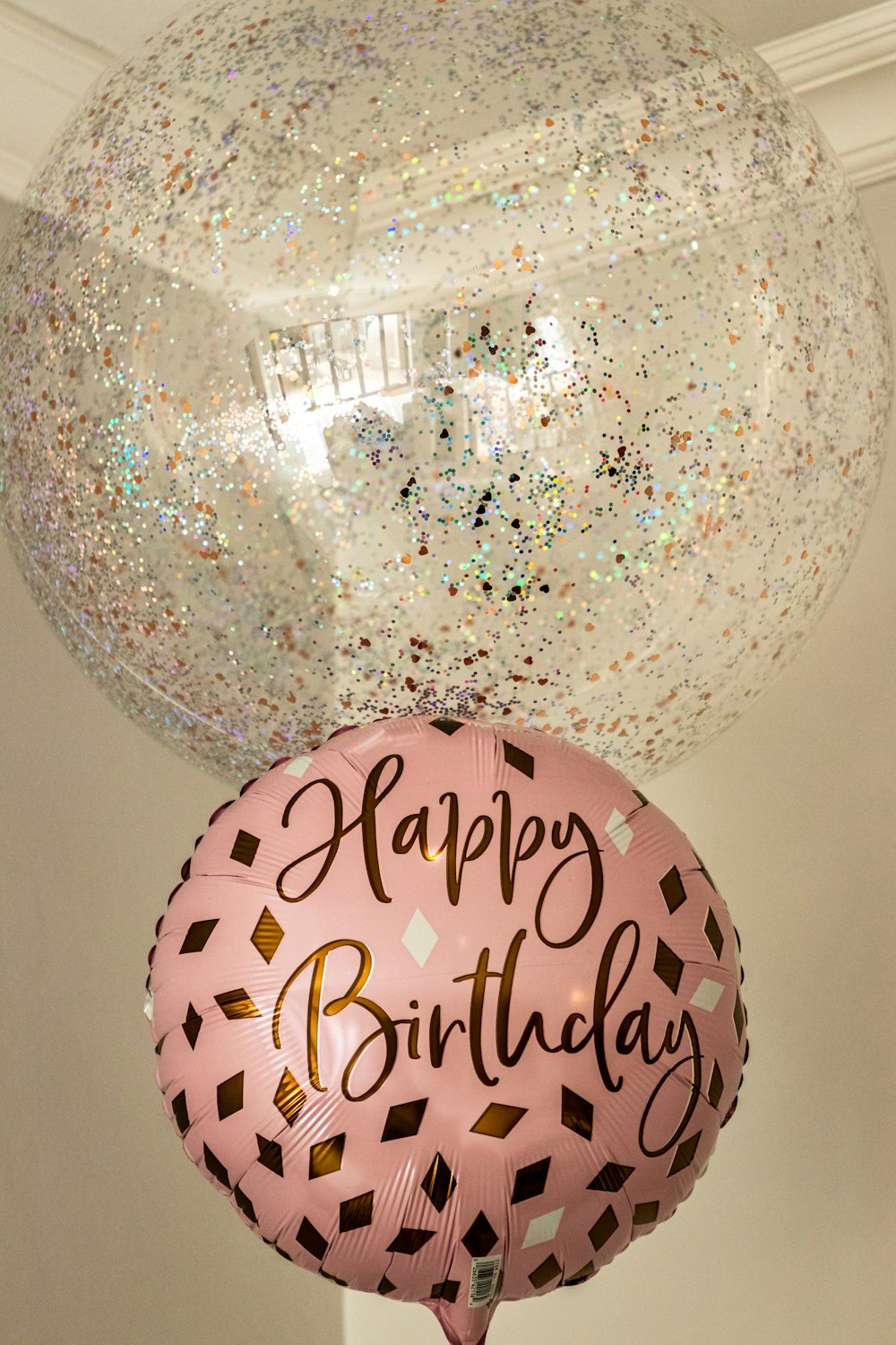 Dos globos que dicen feliz cumpleaños y un globo que dice feliz cumpleaños