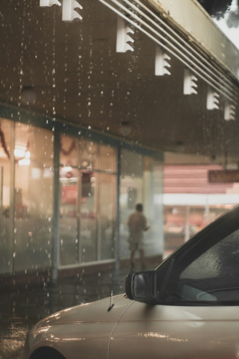 a car parked in front of a building on a rainy day