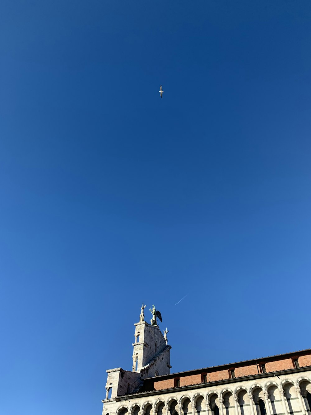 a plane flying over a building with a clock tower