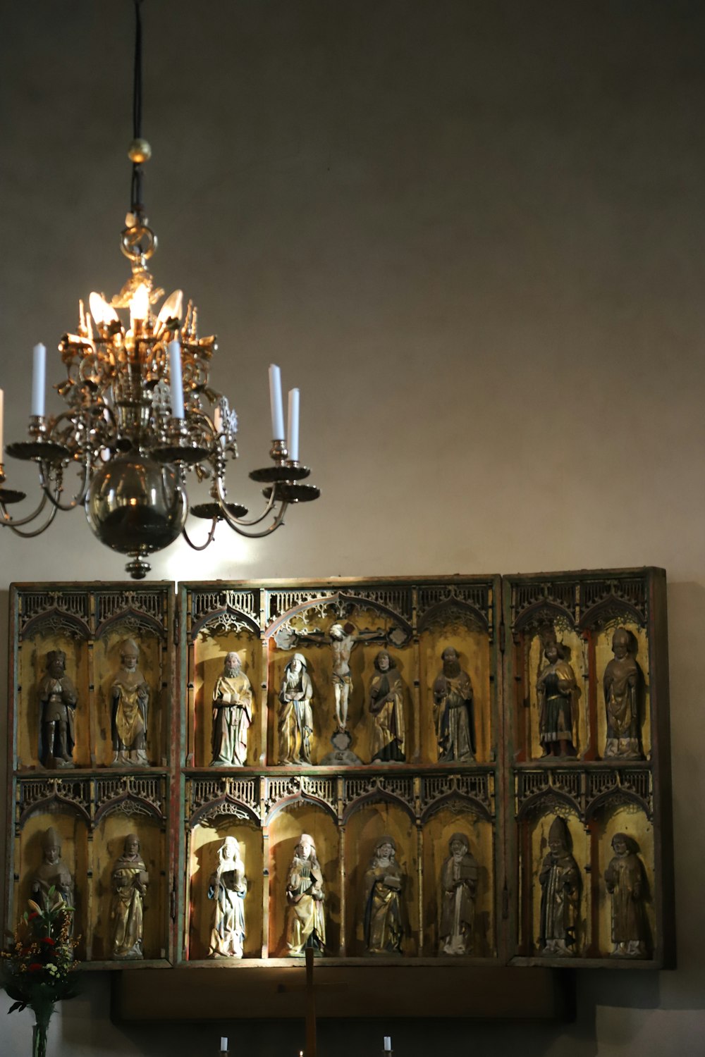 a chandelier hanging from a ceiling next to a wall with pictures on it