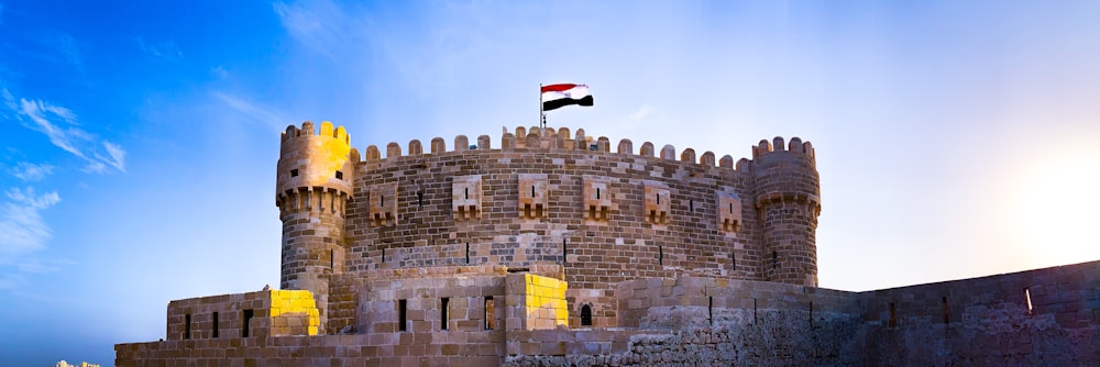 un château surmonté d’un drapeau
