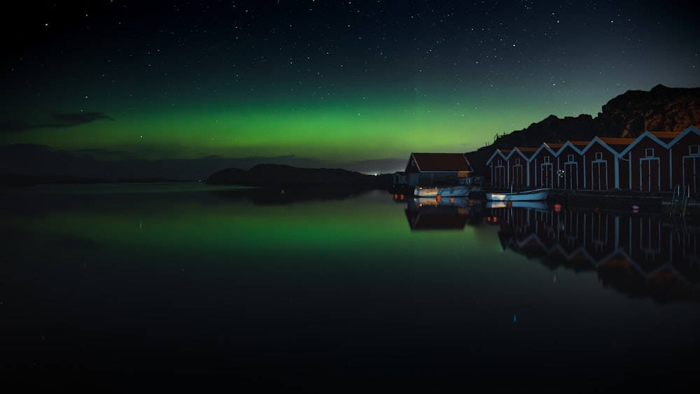 a green and black aurora over a body of water