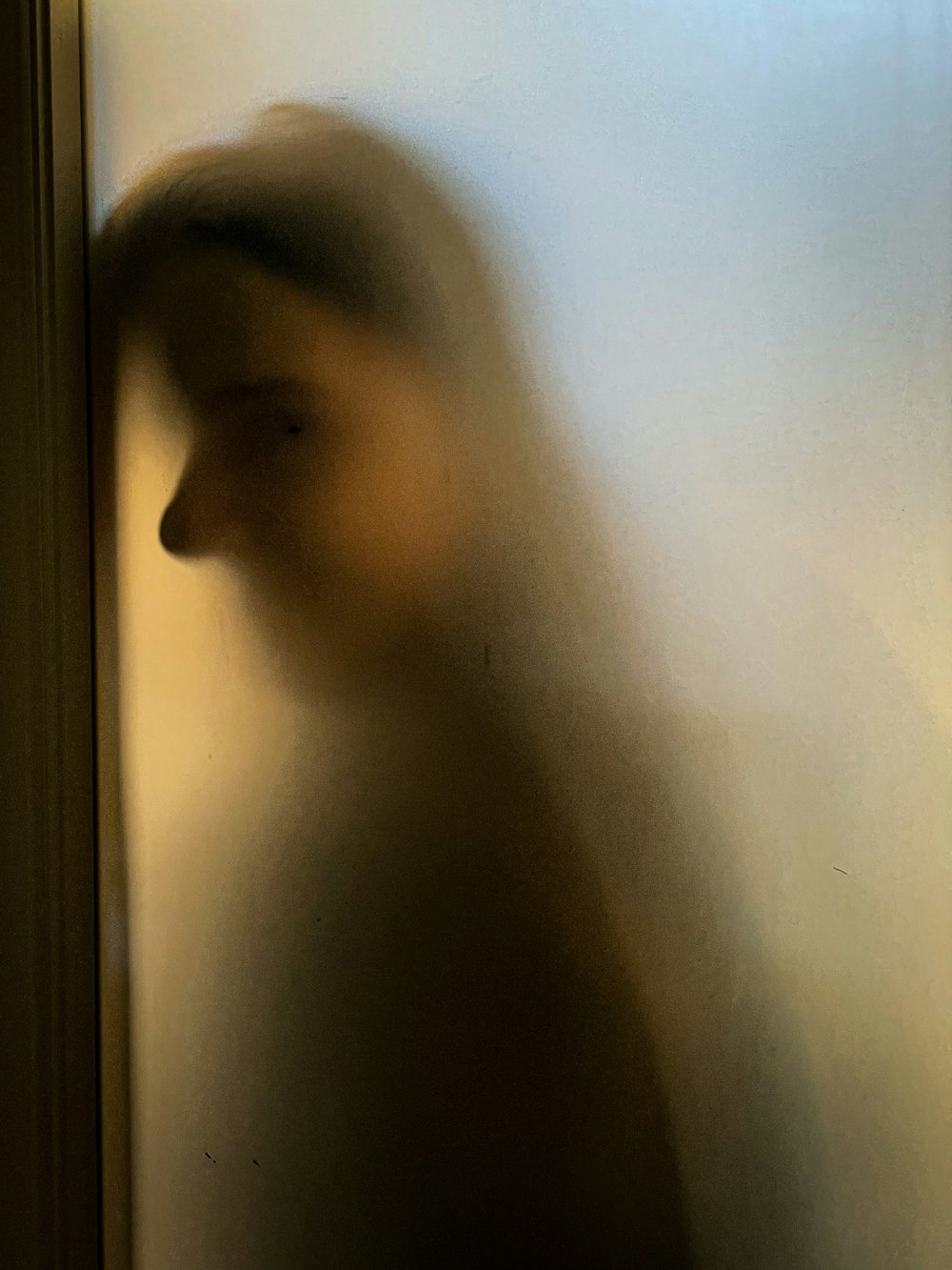 uma foto borrada de uma pessoa em pé na frente de uma porta
