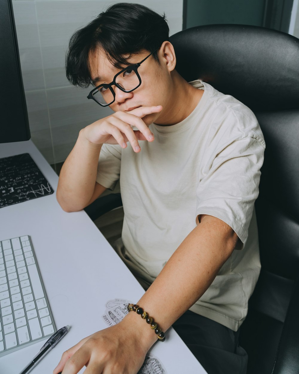 a man sitting at a desk using a laptop computer