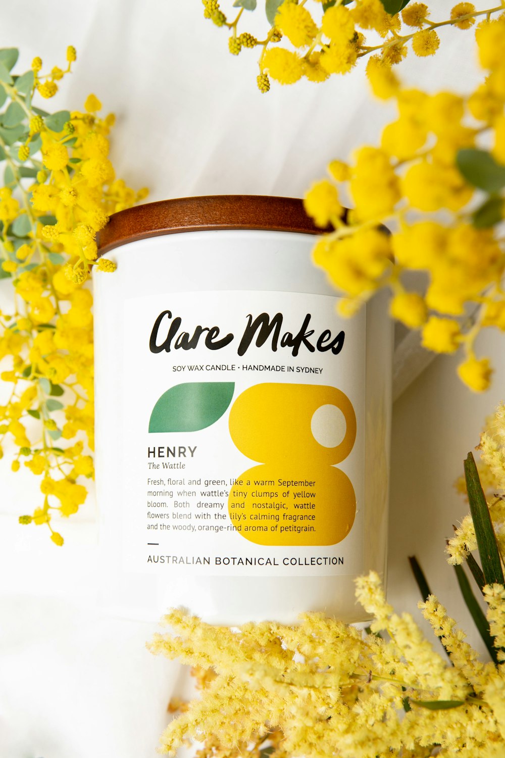 a jar of honey sits next to some yellow flowers