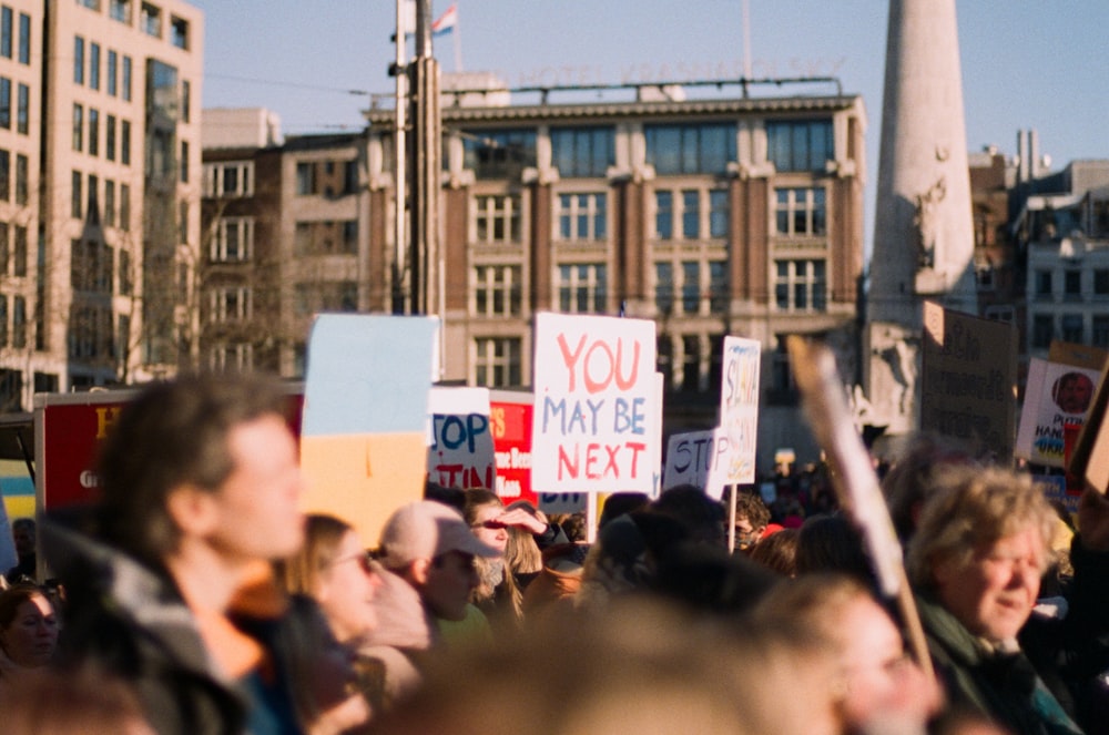 a large group of people holding signs in the street