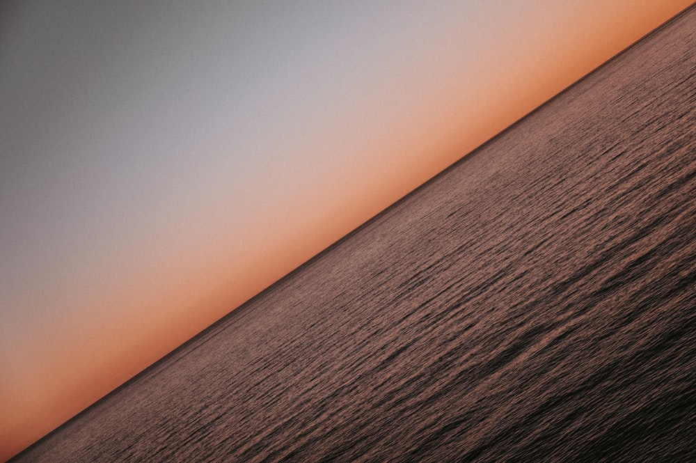 a large body of water with a sky in the background