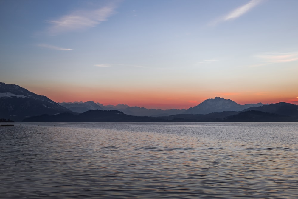 a large body of water with mountains in the background