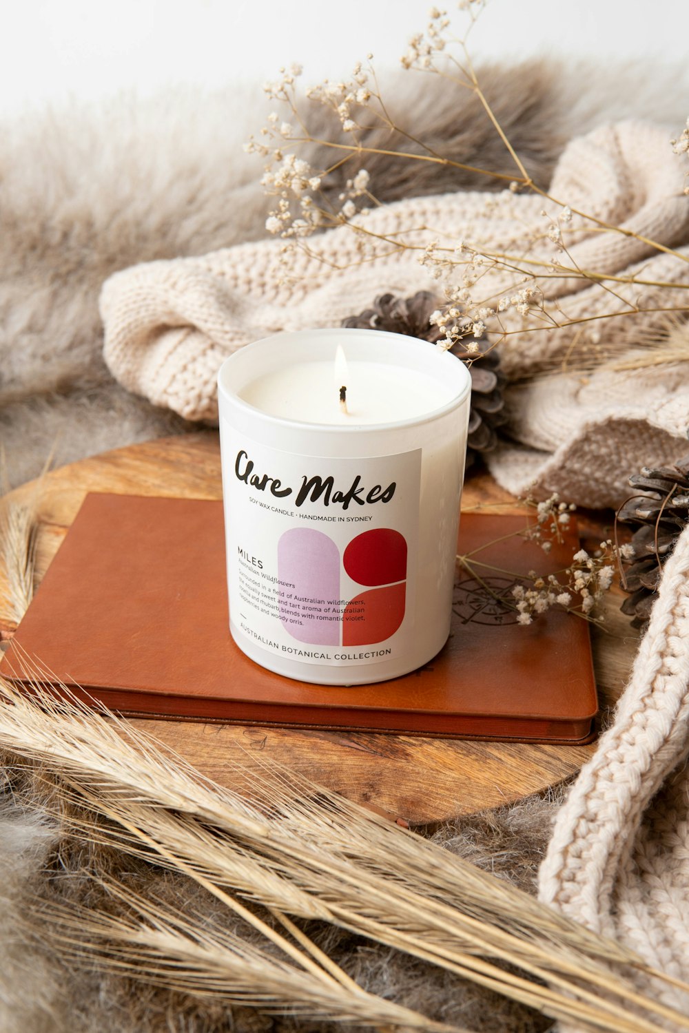 a white candle sitting on top of a wooden board