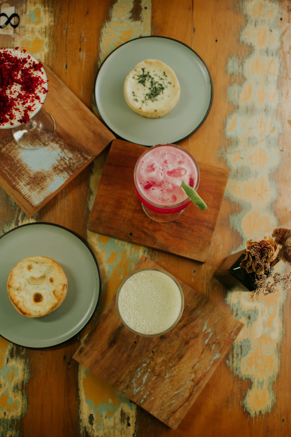 a wooden table topped with plates of food and drinks