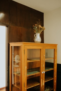 A charming farmhouse wooden hutch cabinet filled with vintage crockery and fresh flowers