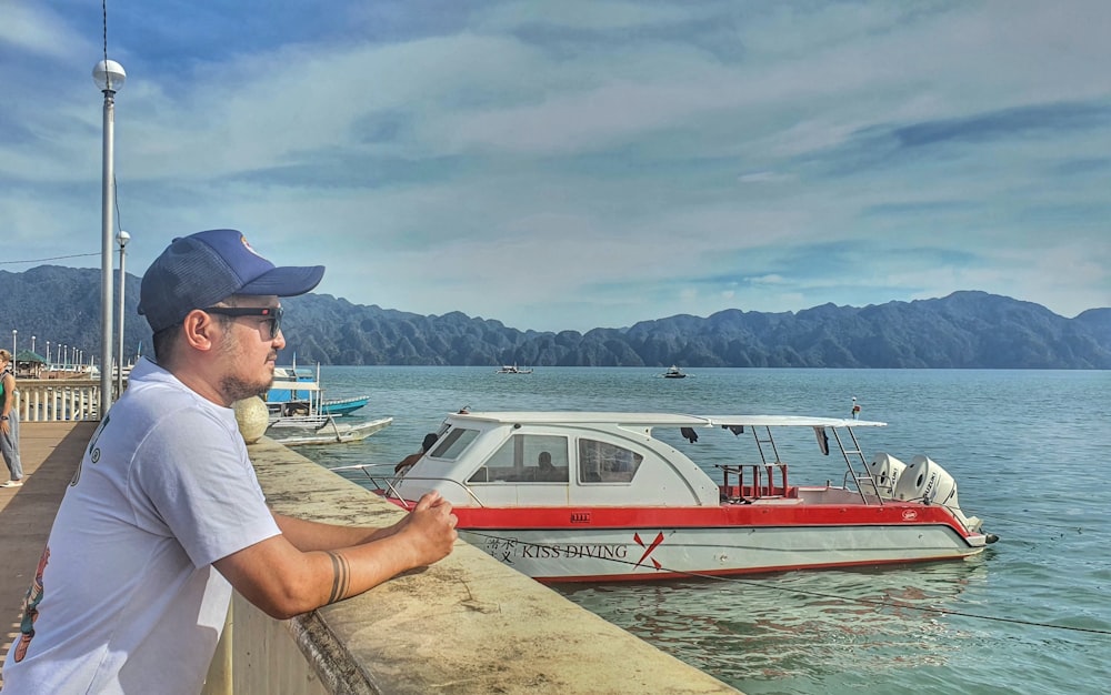 a man standing on a pier next to a boat