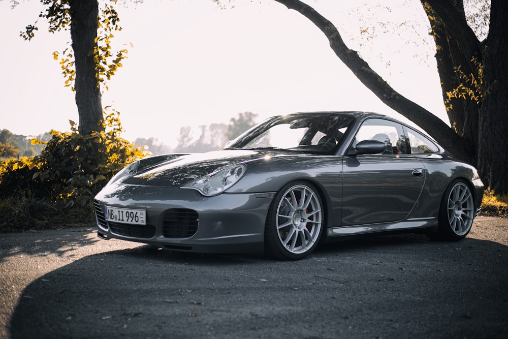 a silver sports car parked on the side of a road