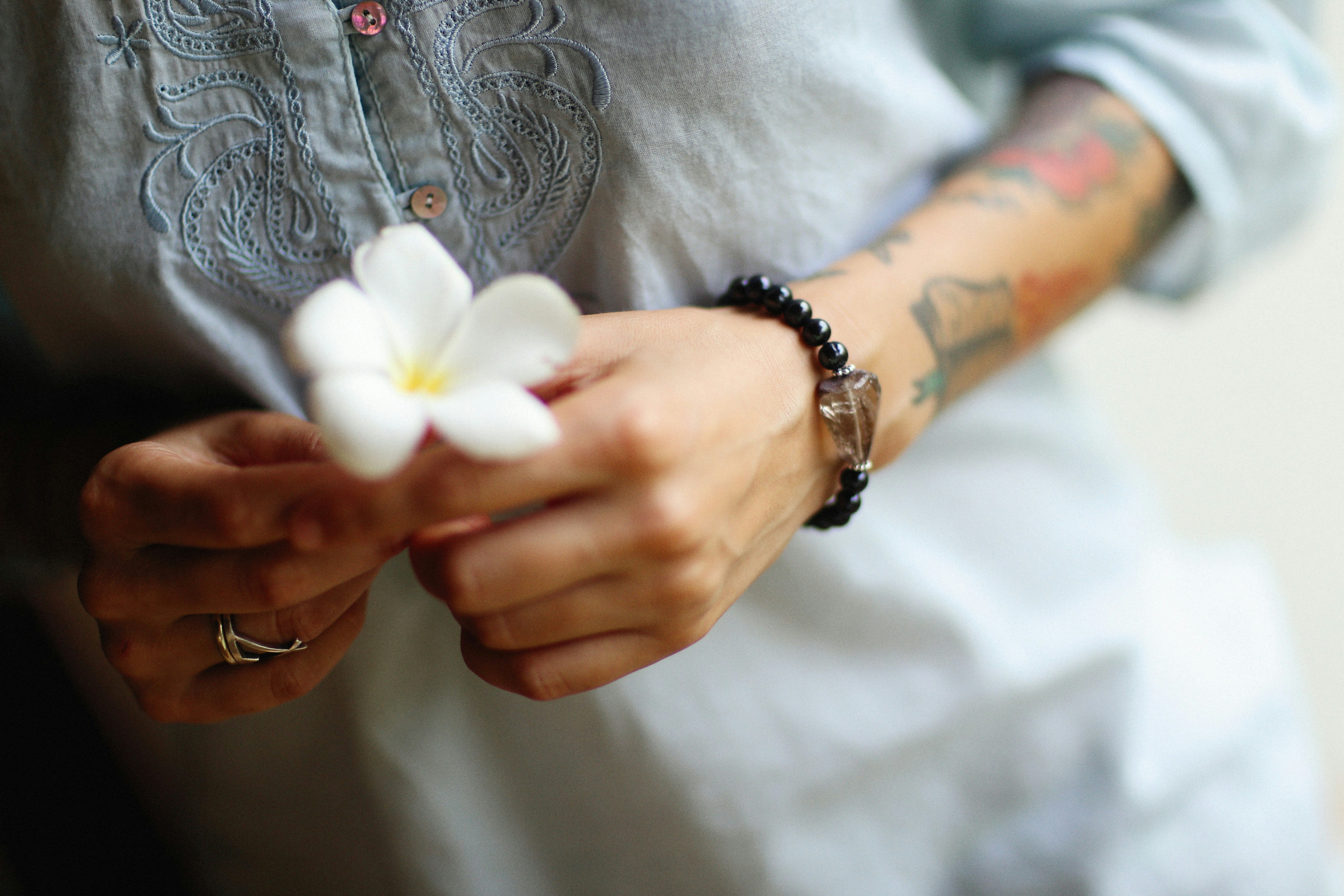 uma pessoa segurando uma flor branca em suas mãos