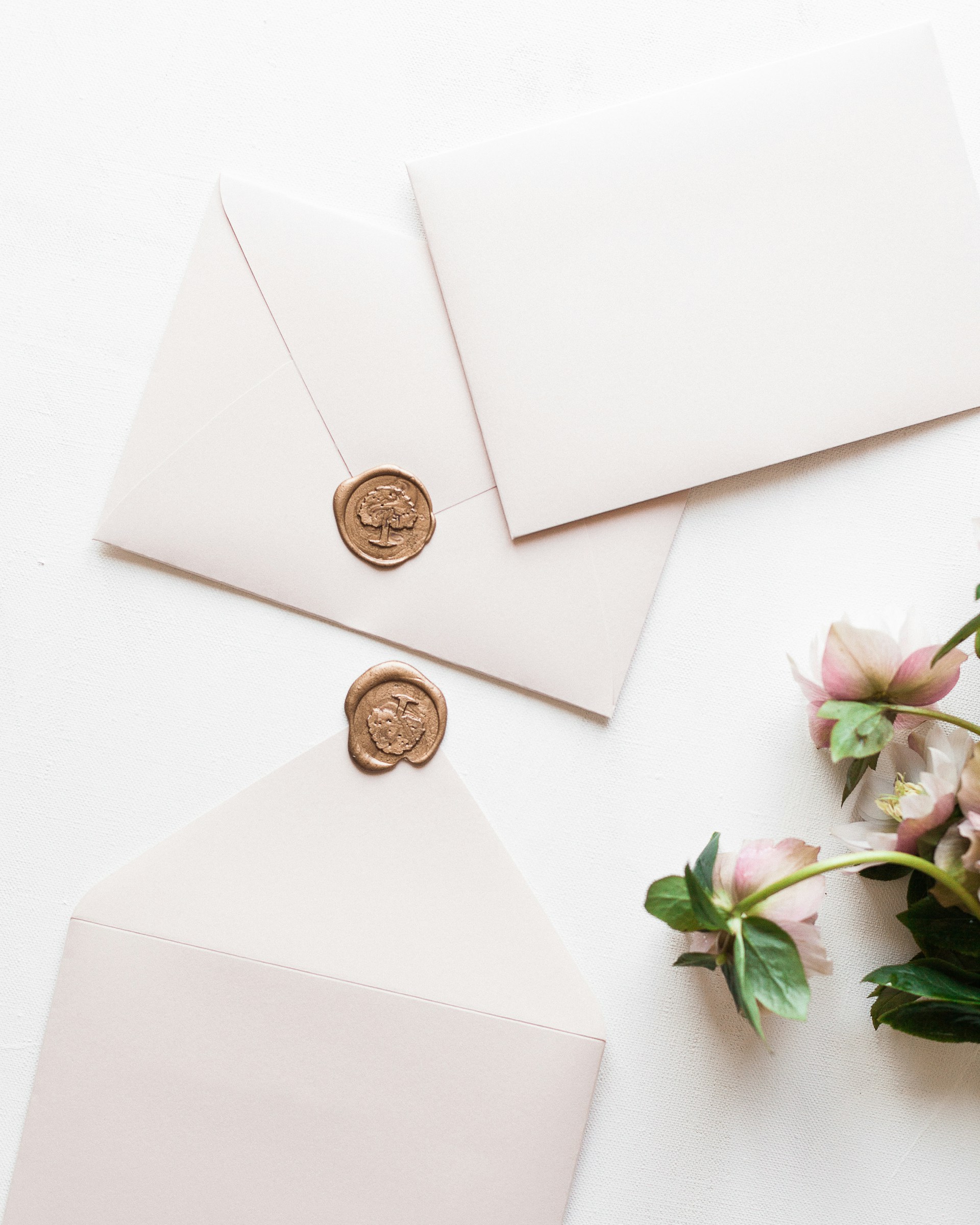 a white envelope with a wax stamp and a bouquet of flowers