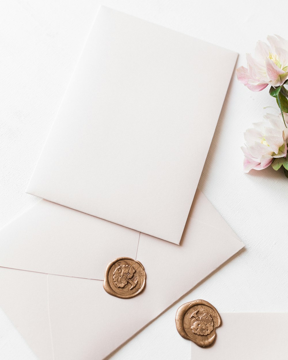 a couple of white envelopes sitting next to each other