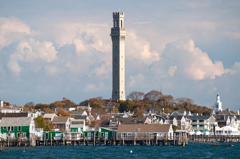 a tall clock tower towering over a city next to a body of water