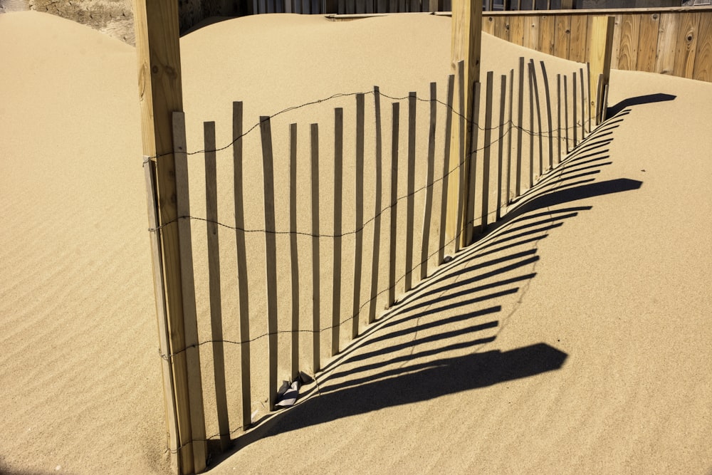 une clôture dans le sable avec une paire de chaussures dessus