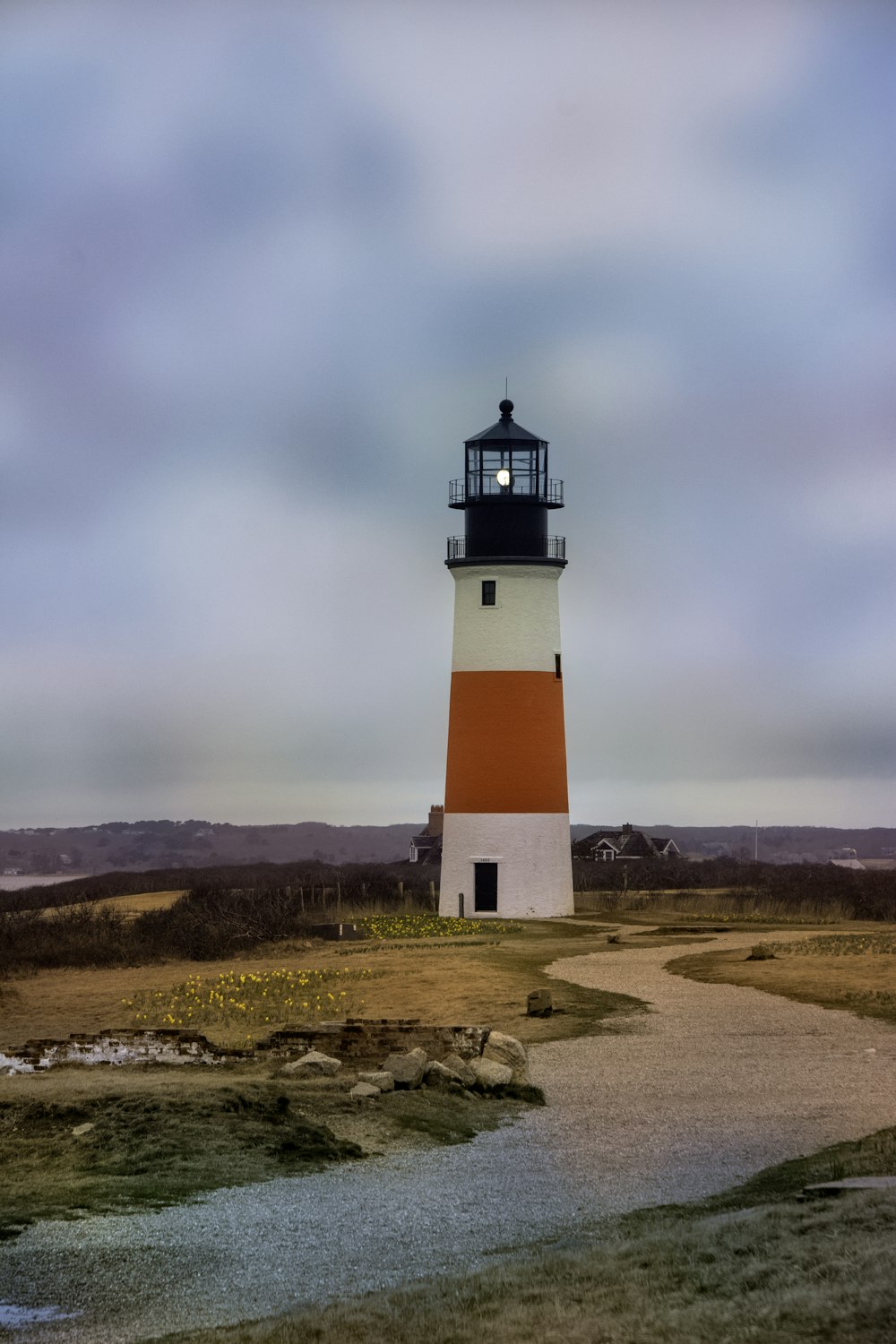 Ein weiß-oranger Leuchtturm an einem bewölkten Tag