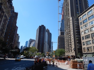 An outdoor view of a busy city street with workers in uniforms.