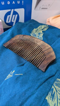 Close-up of a vintage wooden comb resting on a soft linen cloth, sunlight casting gentle shadows.