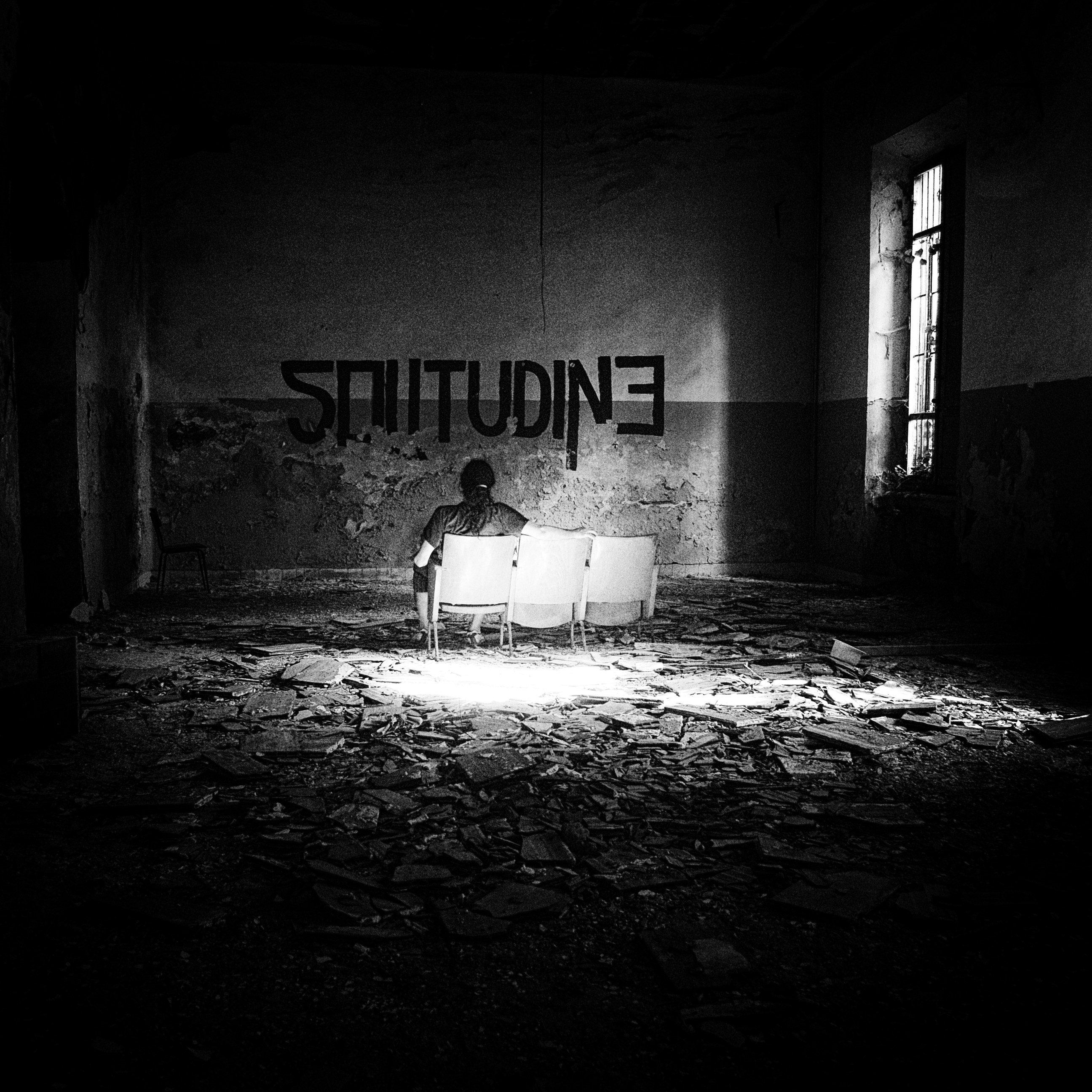 ein Schwarz-Weiß-Foto einer Person, die auf einer Couch sitzt