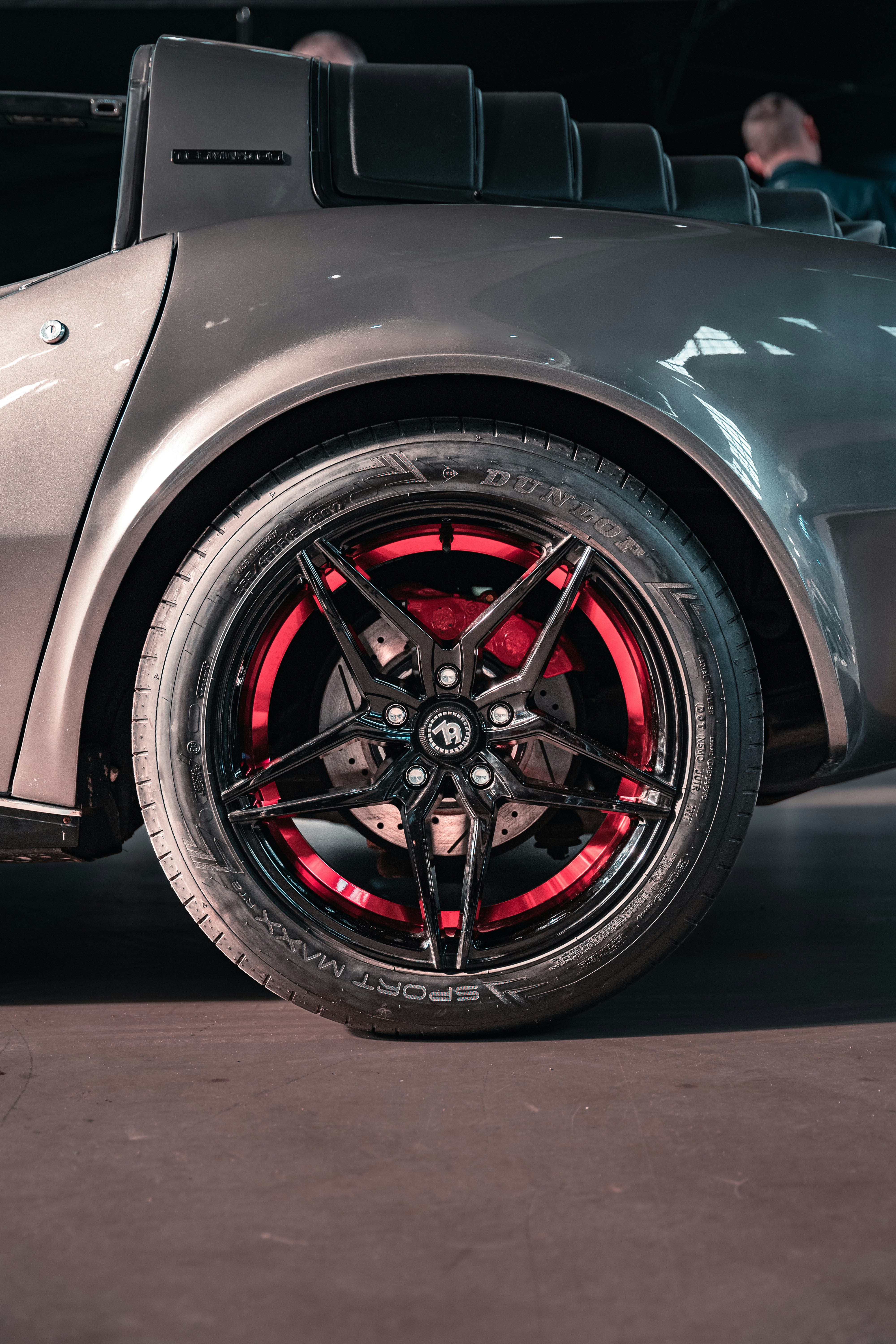 a silver sports car with red spokes parked in a garage