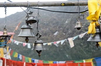 a bunch of bells hanging from a pole