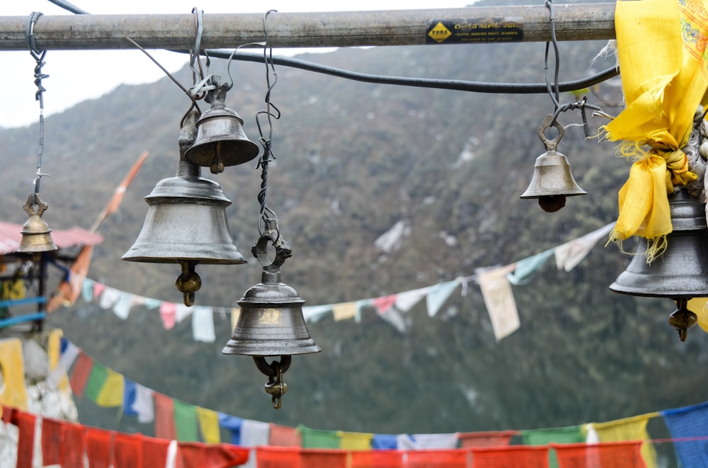 a bunch of bells hanging from a pole
