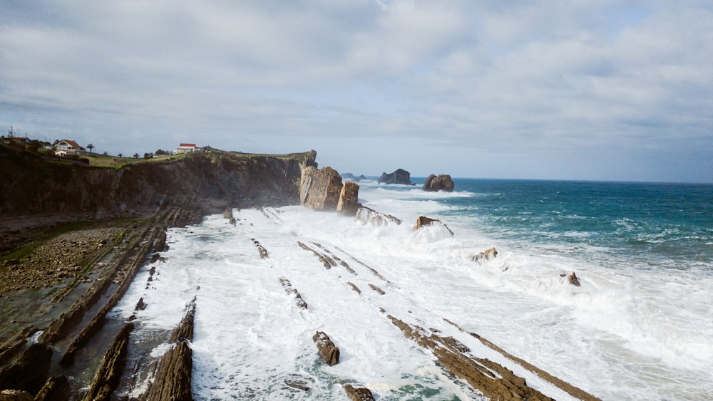 um litoral rochoso com ondas batendo contra as rochas