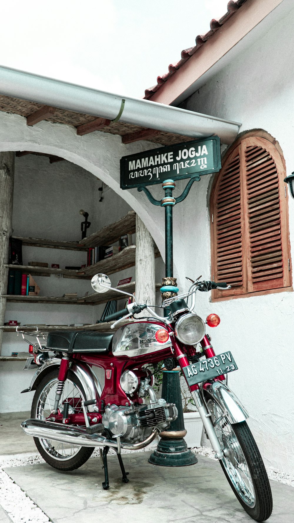 a red motorcycle parked in front of a building