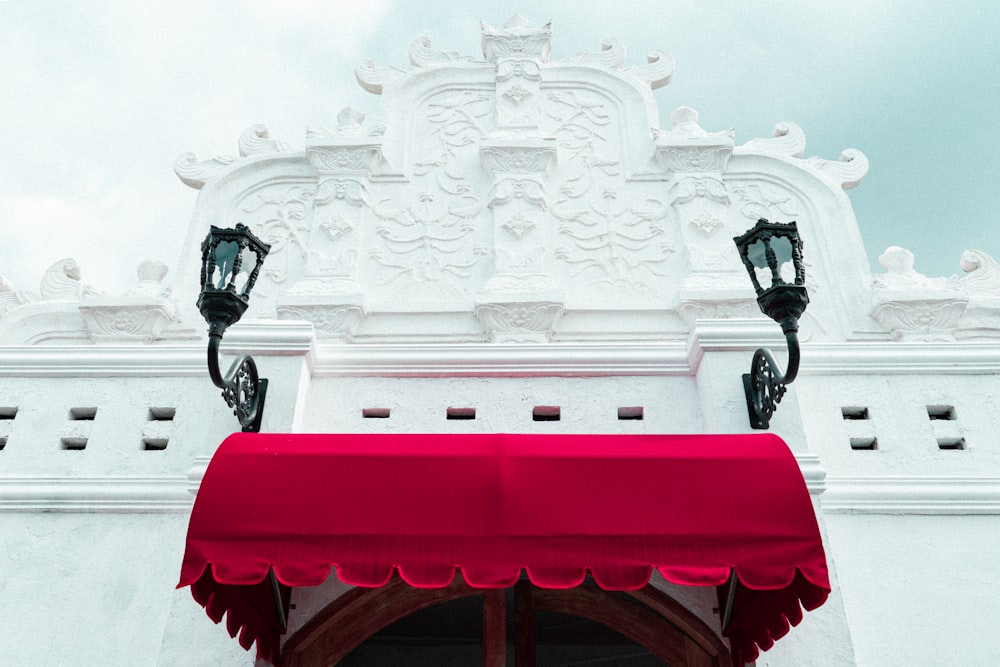 a white building with a red awning