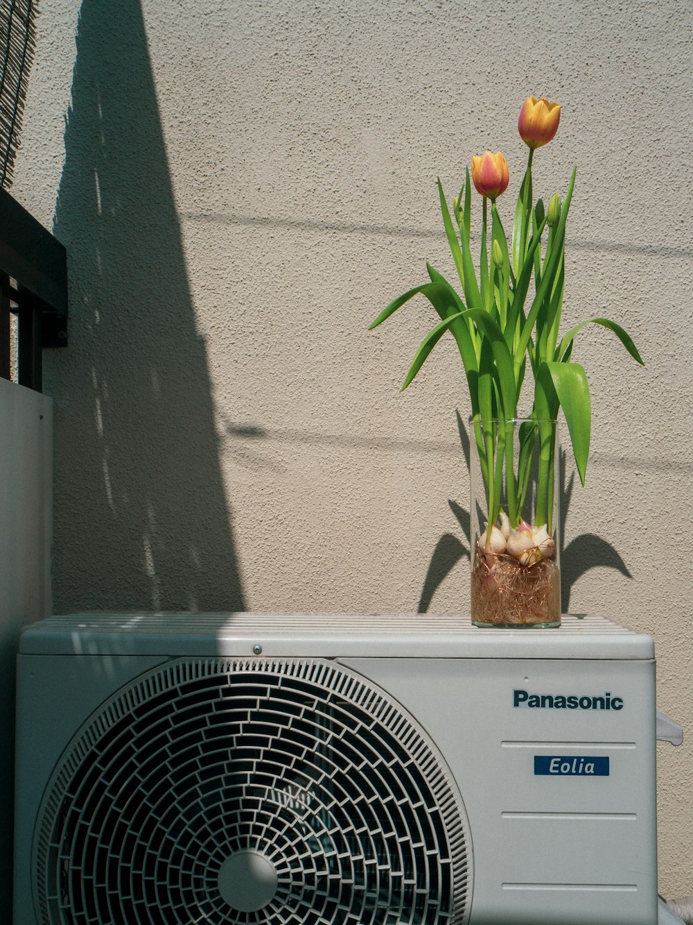 a small air conditioner sitting next to a flower pot