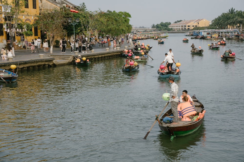 a group of people riding on top of boats down a river