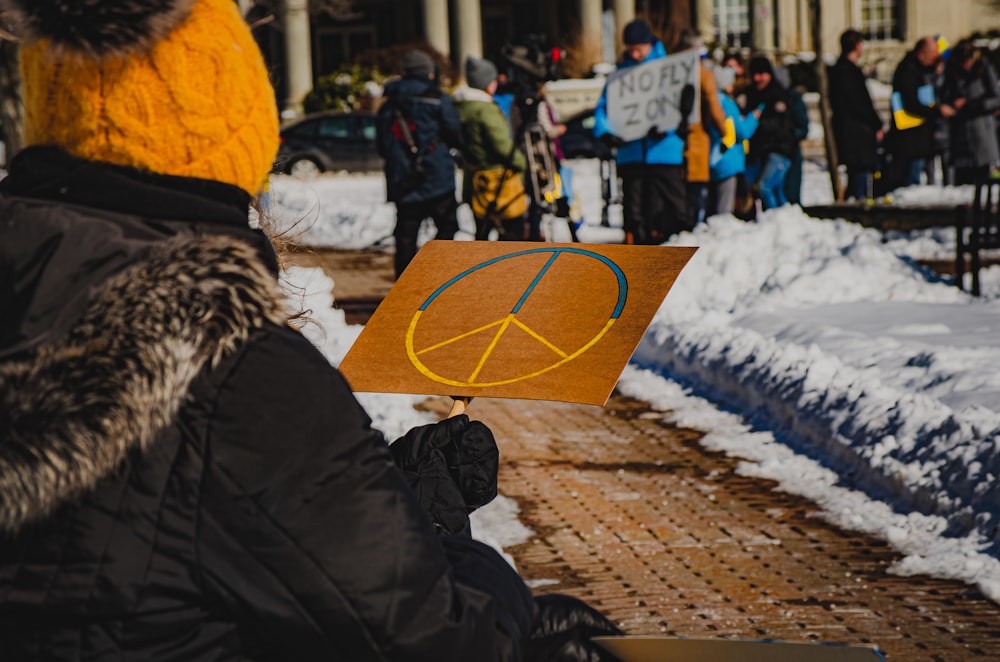 a person holding a sign with a peace sign on it