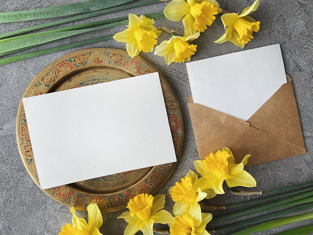 a table topped with yellow flowers and an envelope