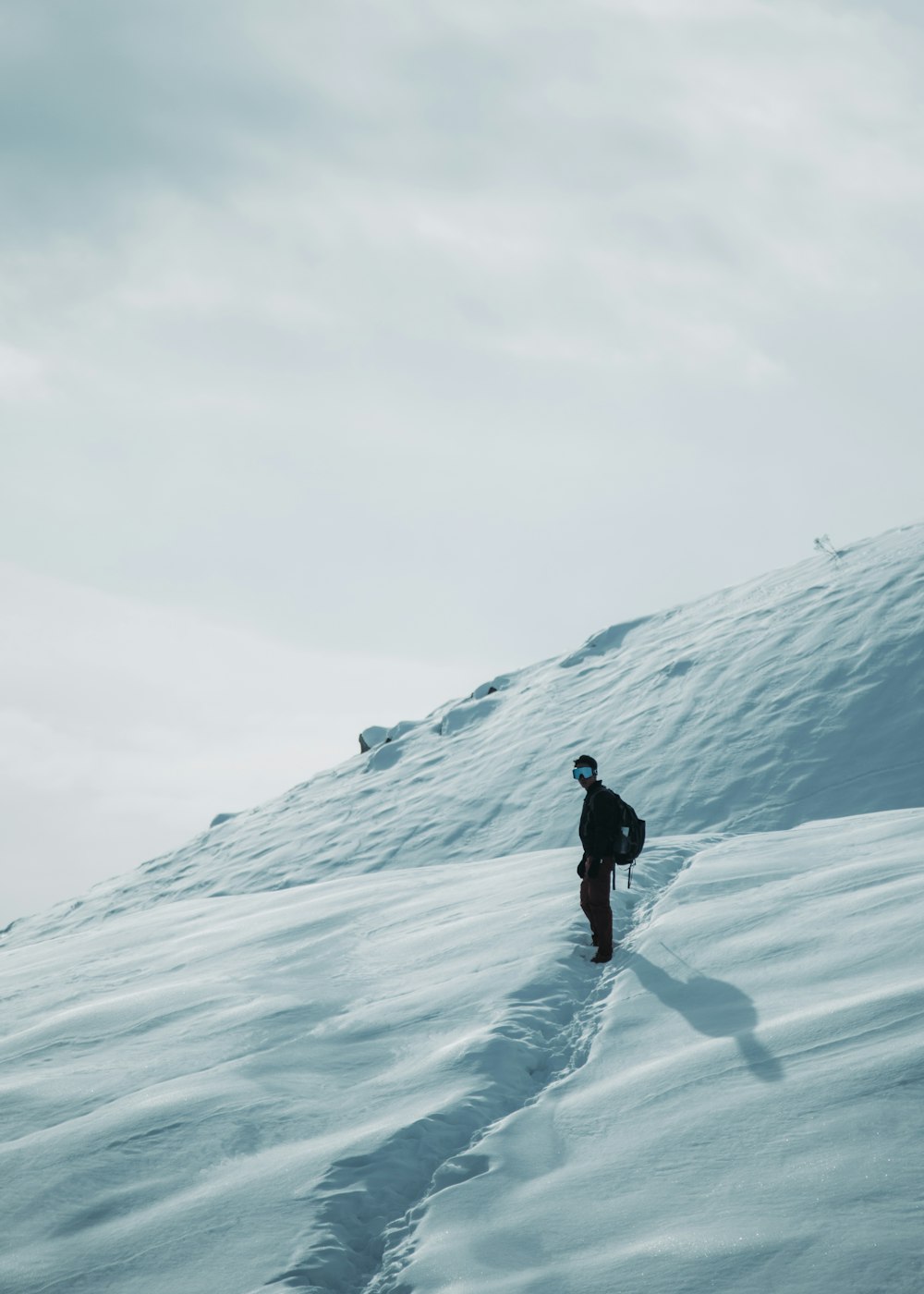 a person walking up a snow covered hill