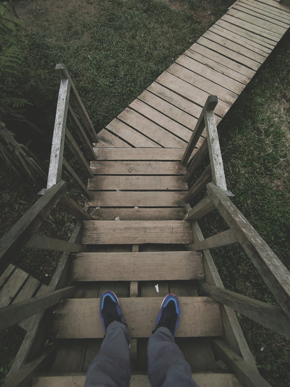 a person standing at the top of a wooden staircase