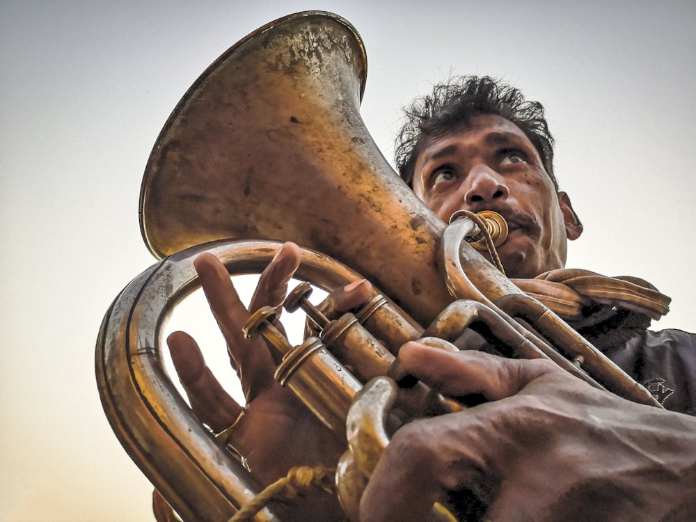 a man playing a trumpet in front of a sky