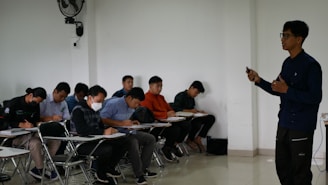 a man standing in front of a classroom full of students