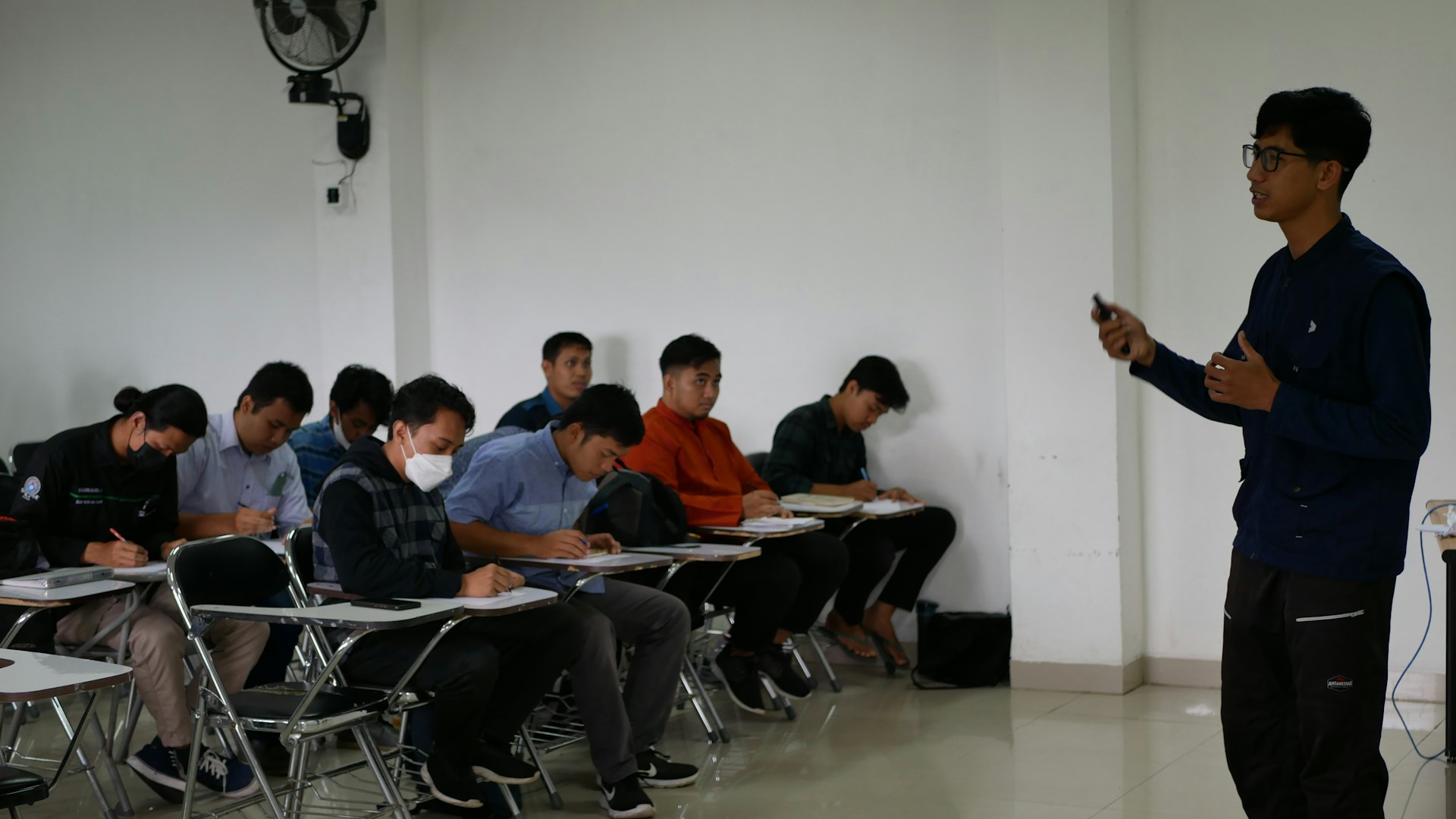a man standing in front of a classroom full of students
