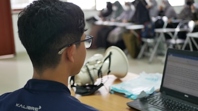 a man sitting at a desk using a laptop computer