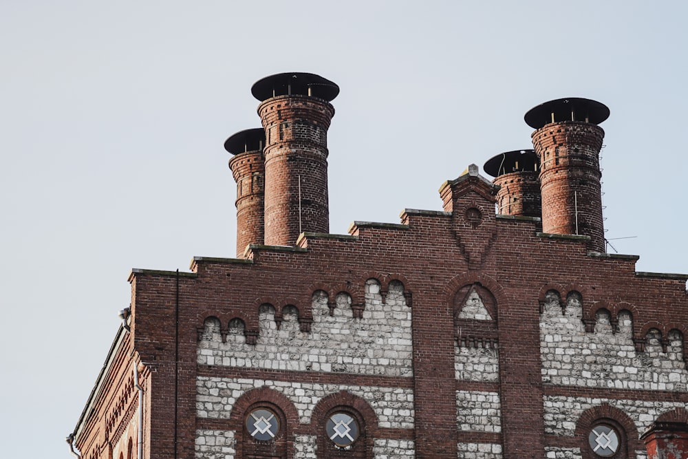 a brick building with two chimneys and a clock