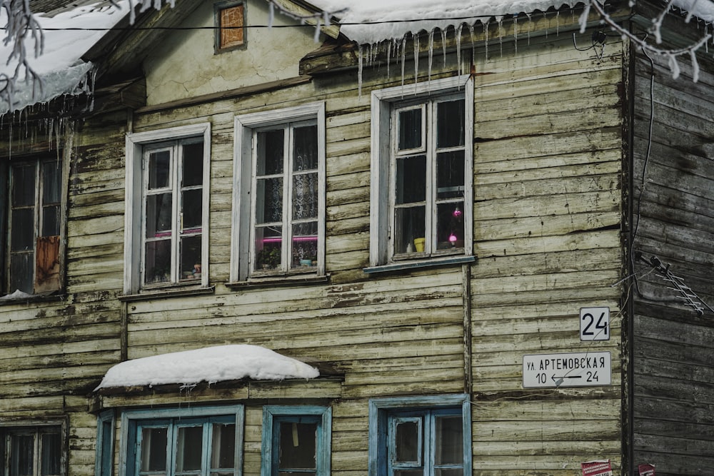 an old wooden house with snow on the roof