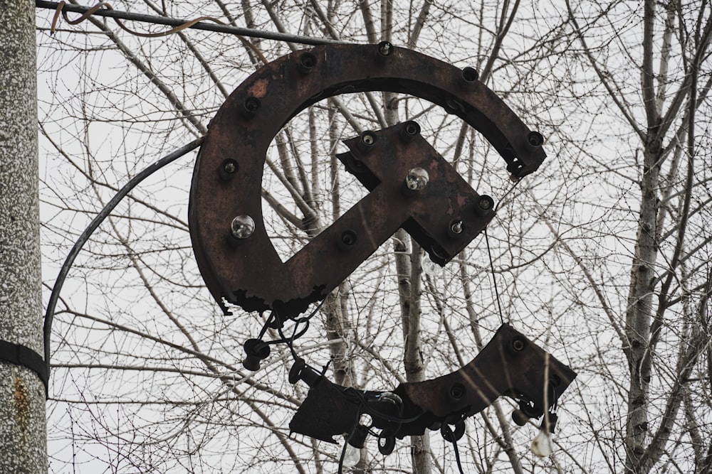 ein großes Metallschild, das an der Seite eines Baumes hängt