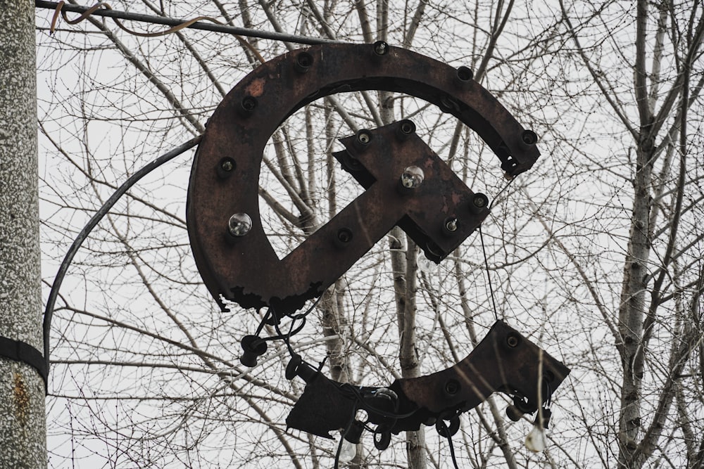 a large metal sign hanging from the side of a tree